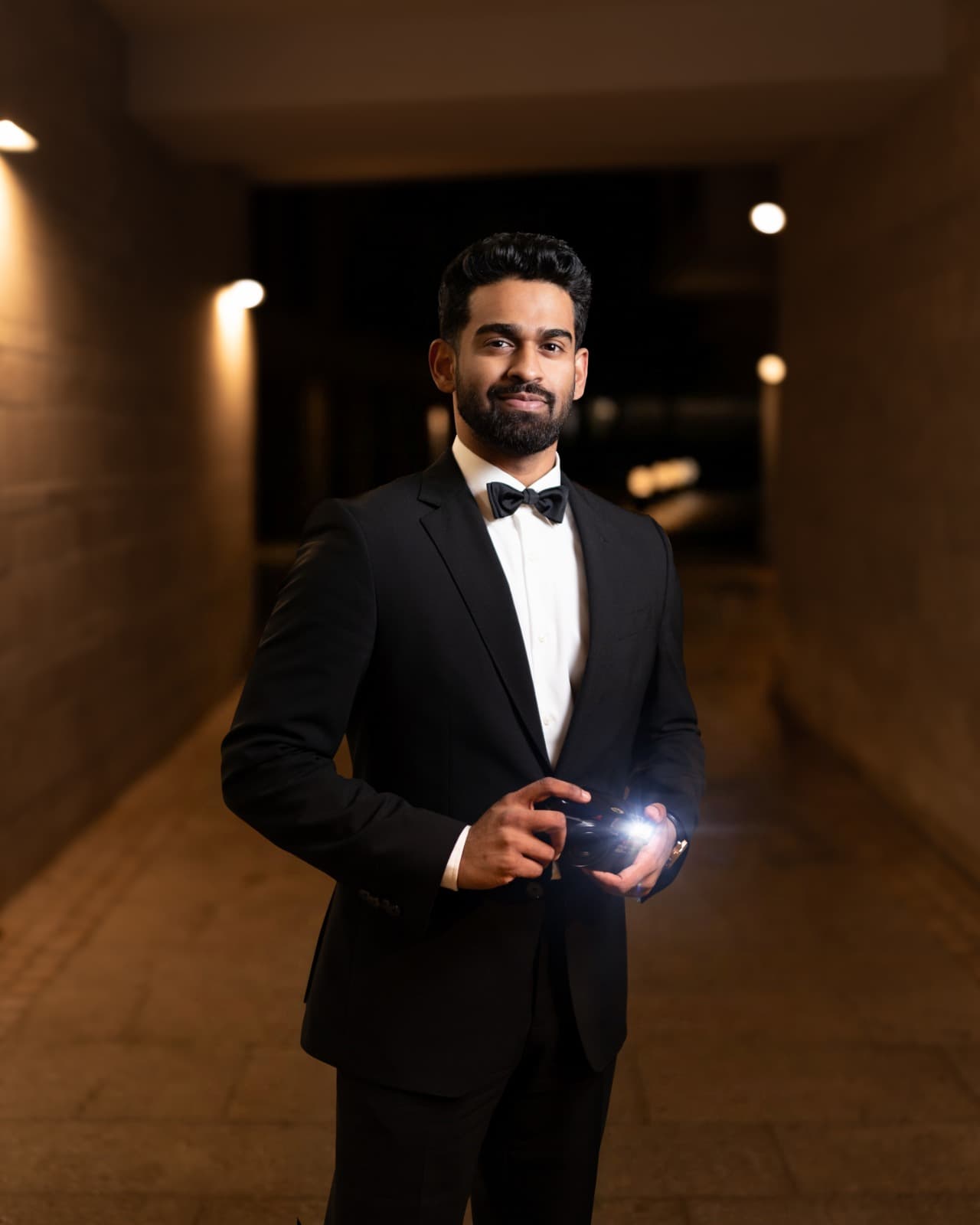 David George holding a camera in formal black tie